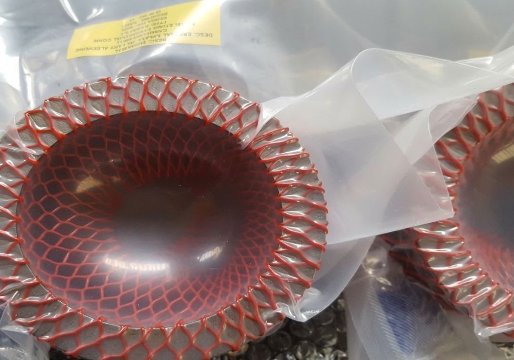 Precision-Machined Ring Component in Protective Storage Machined metal ring component secured in red protective mesh and sealed packaging, prepared for controlled storage and future installation in industrial equipment.