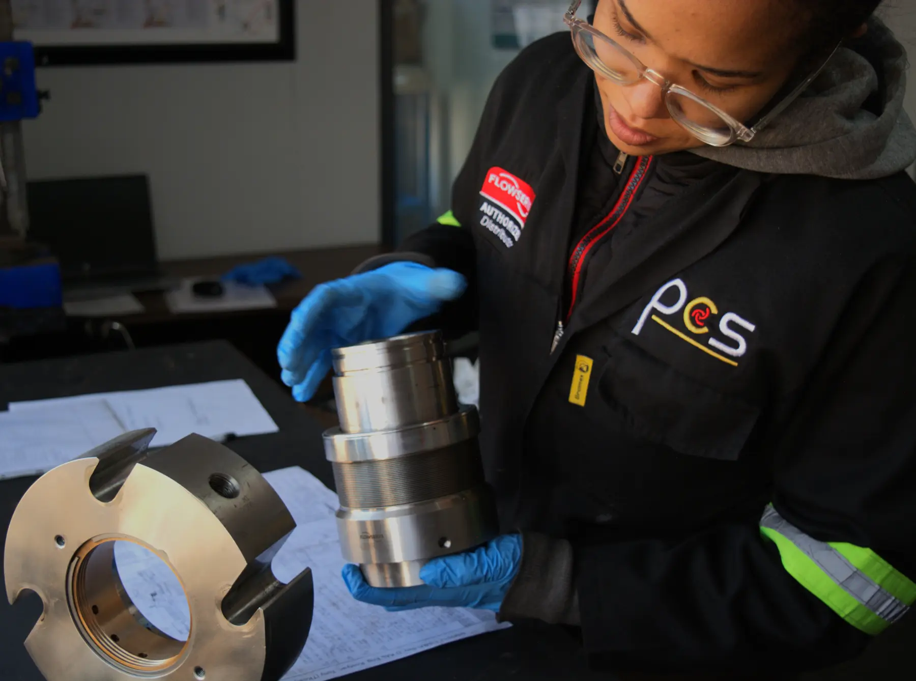 PCS technician inspecting an industrial component in the workshop