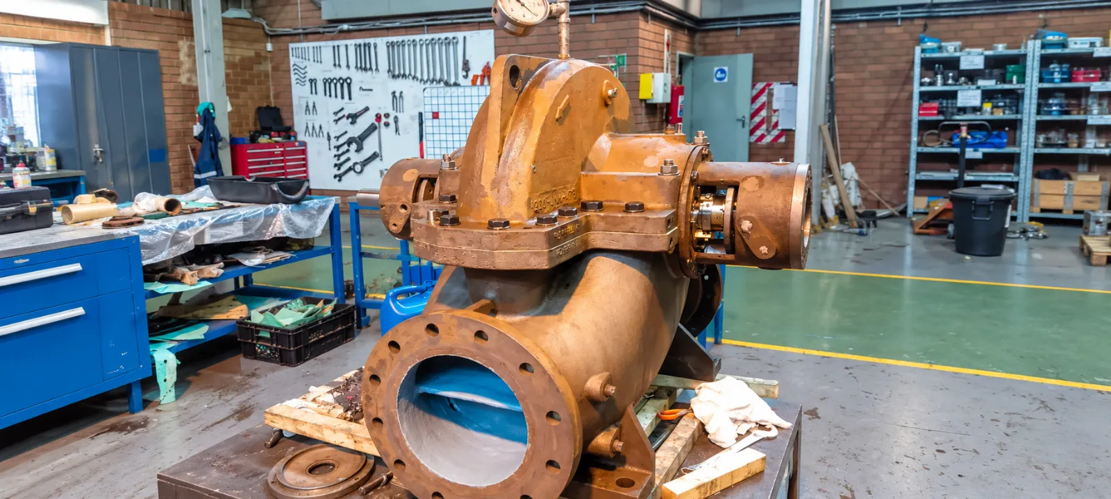 Large industrial pump with flanged inlet and shaft coupling in the PCS workshop
