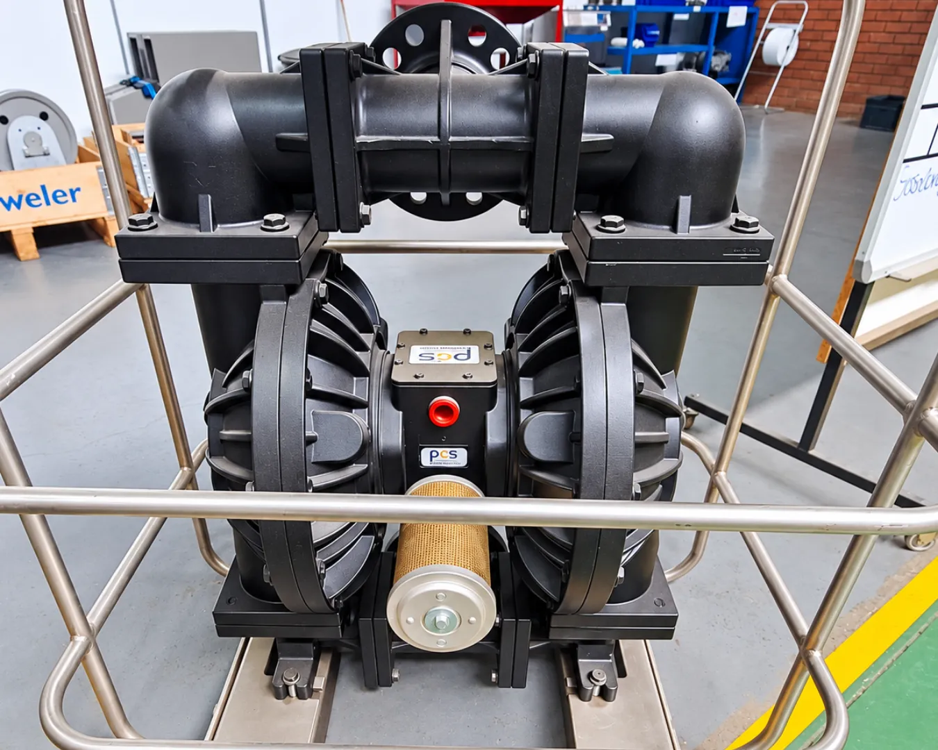 Industrial diaphragm pump with PCS branding in the PCS workshop.