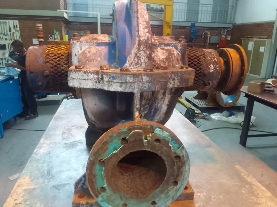 Industrial pump showing visible wear and corrosion in the PCS workshop before repair assessment