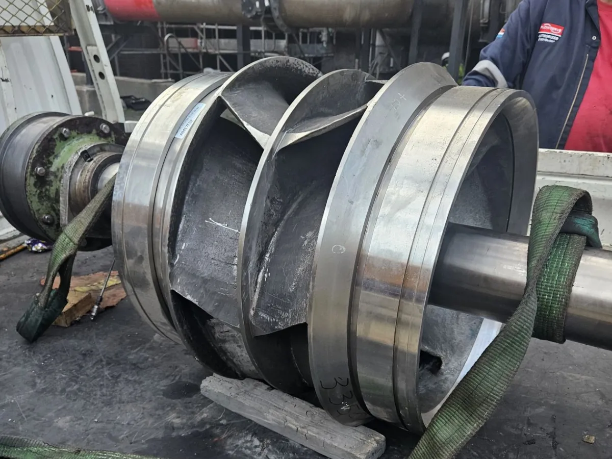 Industrial pump impeller and shaft assembly positioned on a workshop workbench
