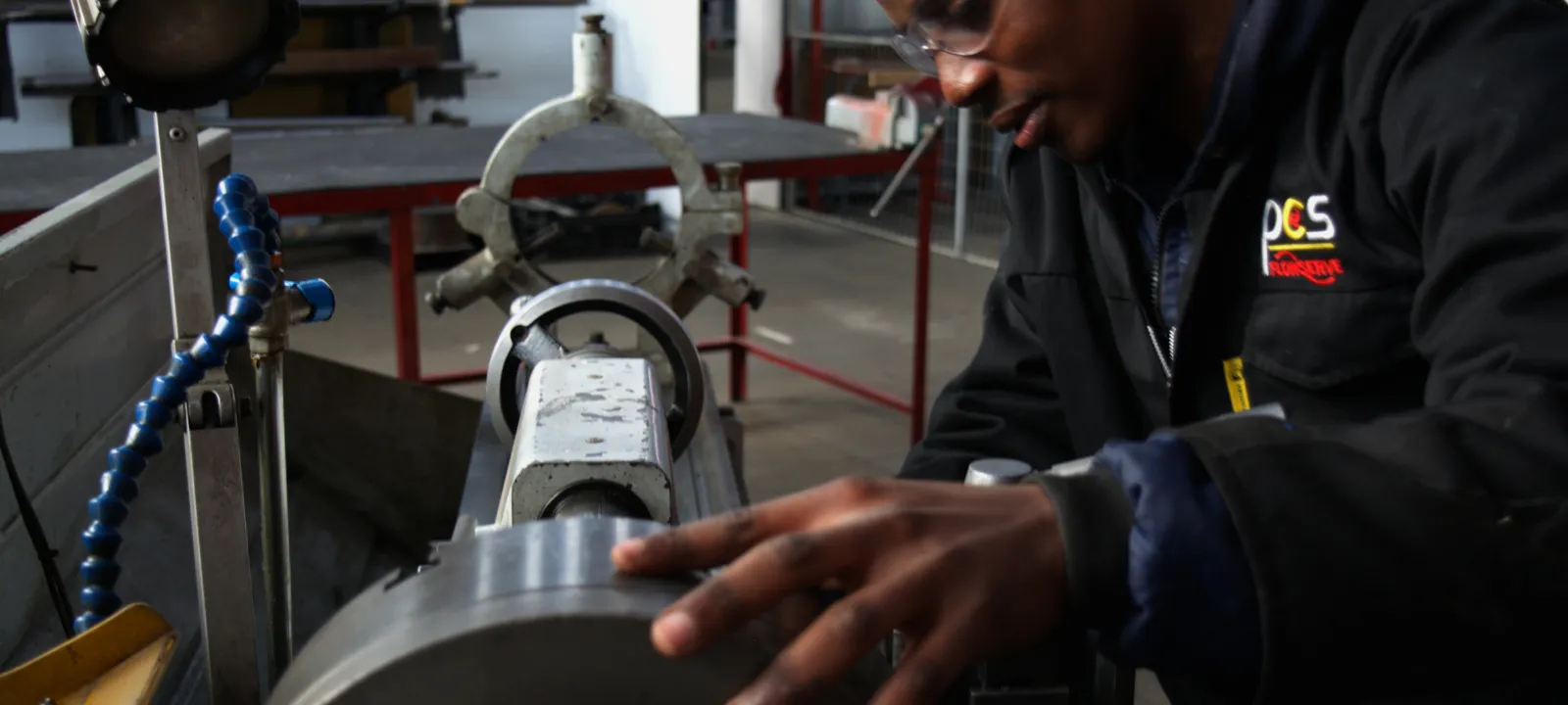 PCS technician working with an industrial pump component in the workshop